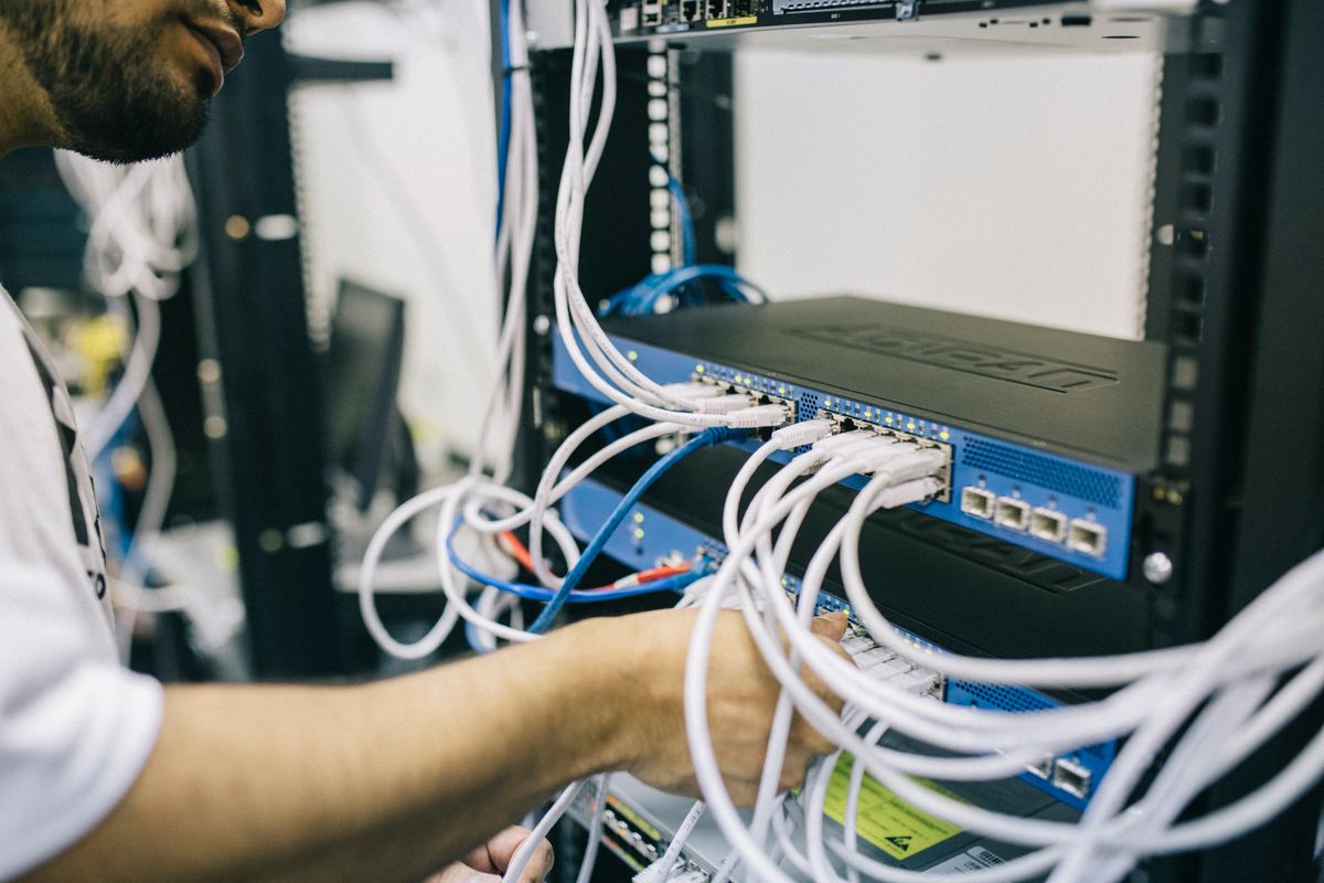 Technician configuring network equipment in a server rack